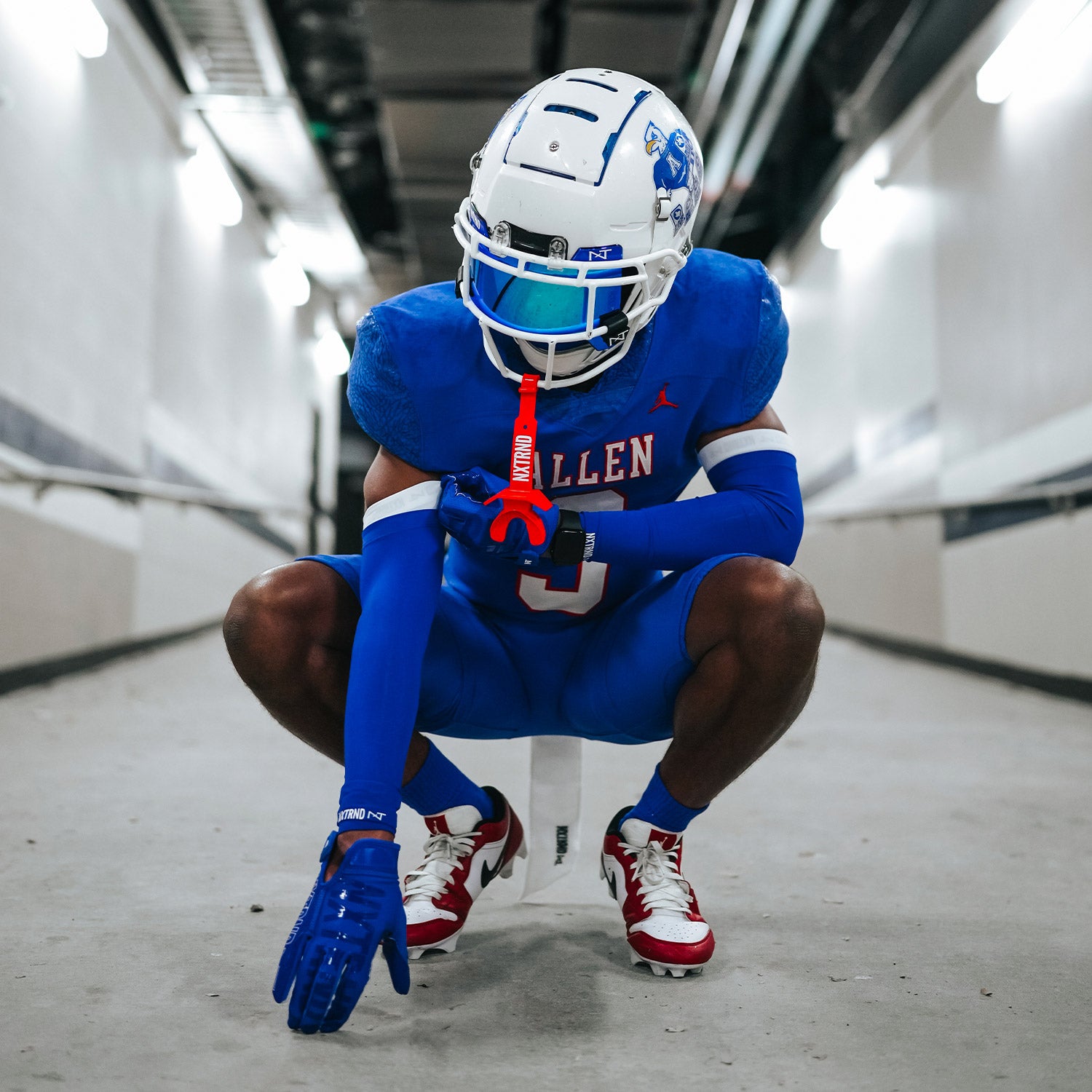 High School Football Player Wearing NXTRND Double Compression Arm Sleeves Blue and TWO Mouthguard Red