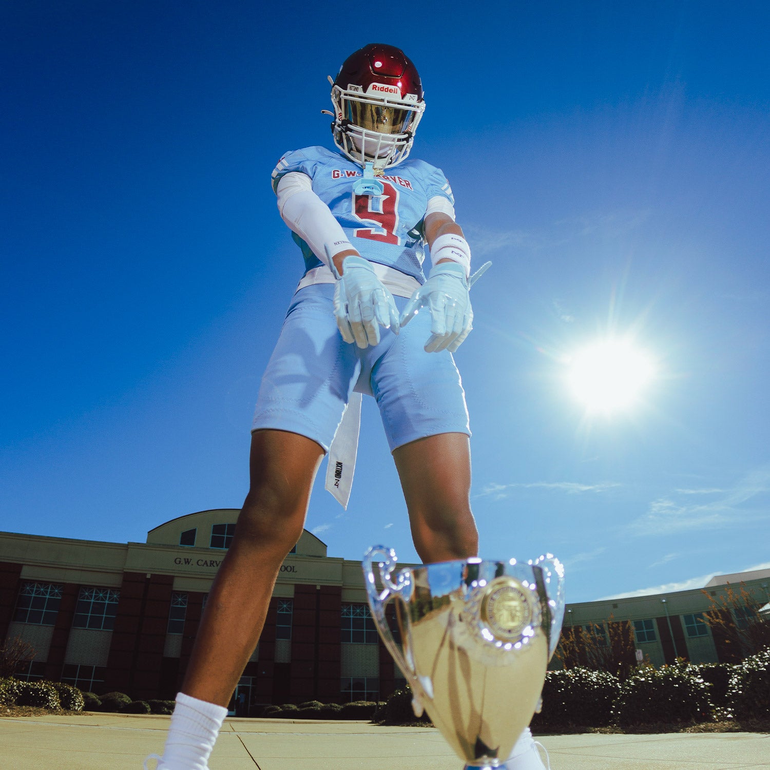High School Football Player Wearing NXTRND G1 Pro Football Gloves Columbia Blue and Compression Sleeve White Close Up