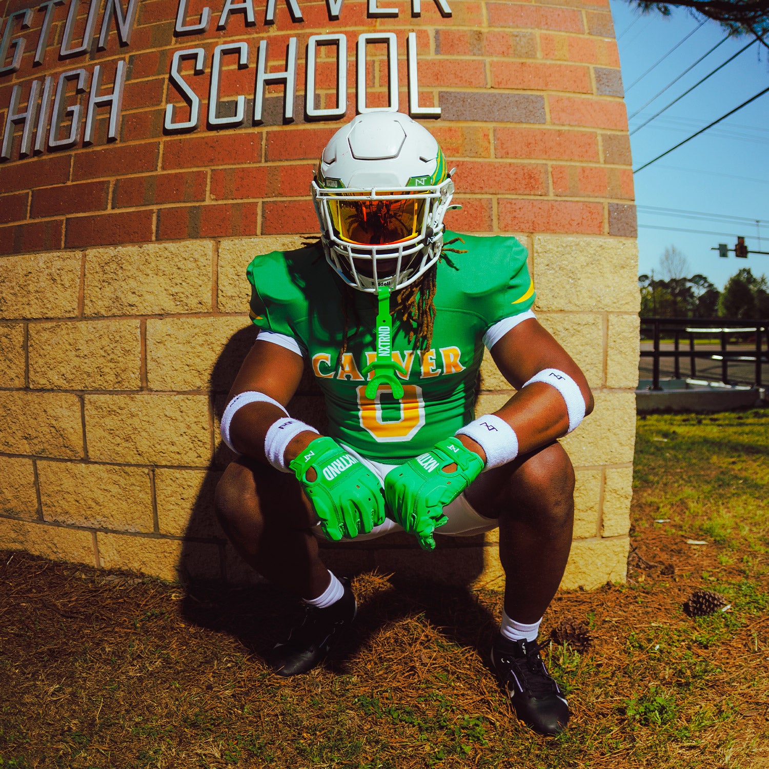 High School Football Player Outside Wearing NXTRND G3 Pro Padded Football Gloves Green and VZR3 Football Visor Gold