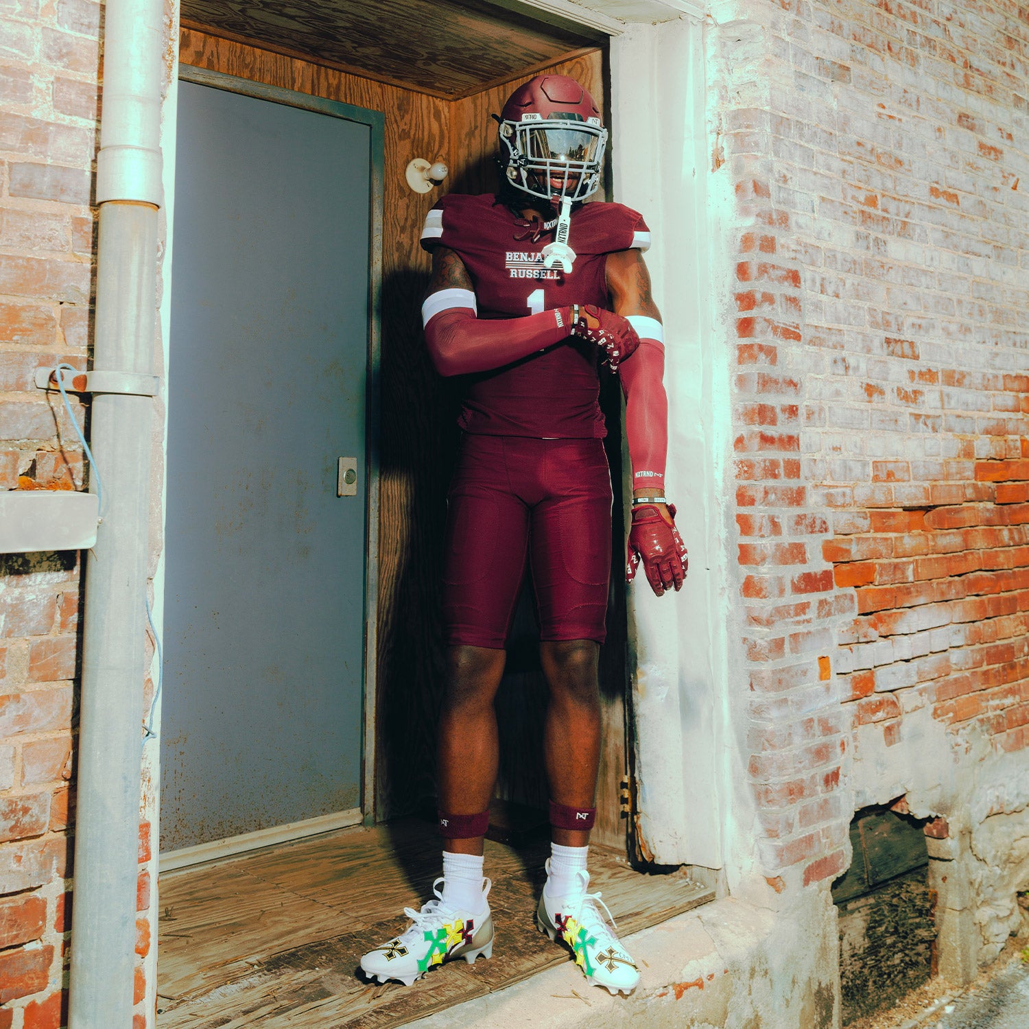 High School Football Player Wearing NXTRND Double Layer Compression Arm Sleeve Maroon and TWO Mouthguard White