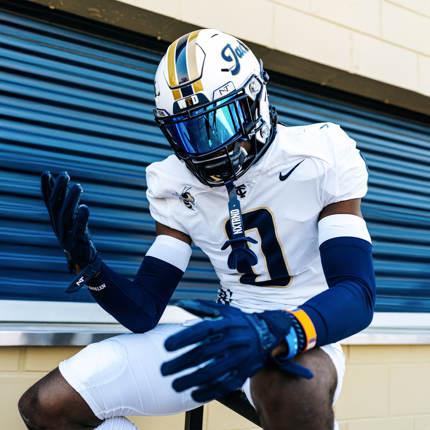 High School Football Player Wearing NXTRND Double Layer Compression Arm Sleeve Navy Blue and VZR3 Football Visor Blue