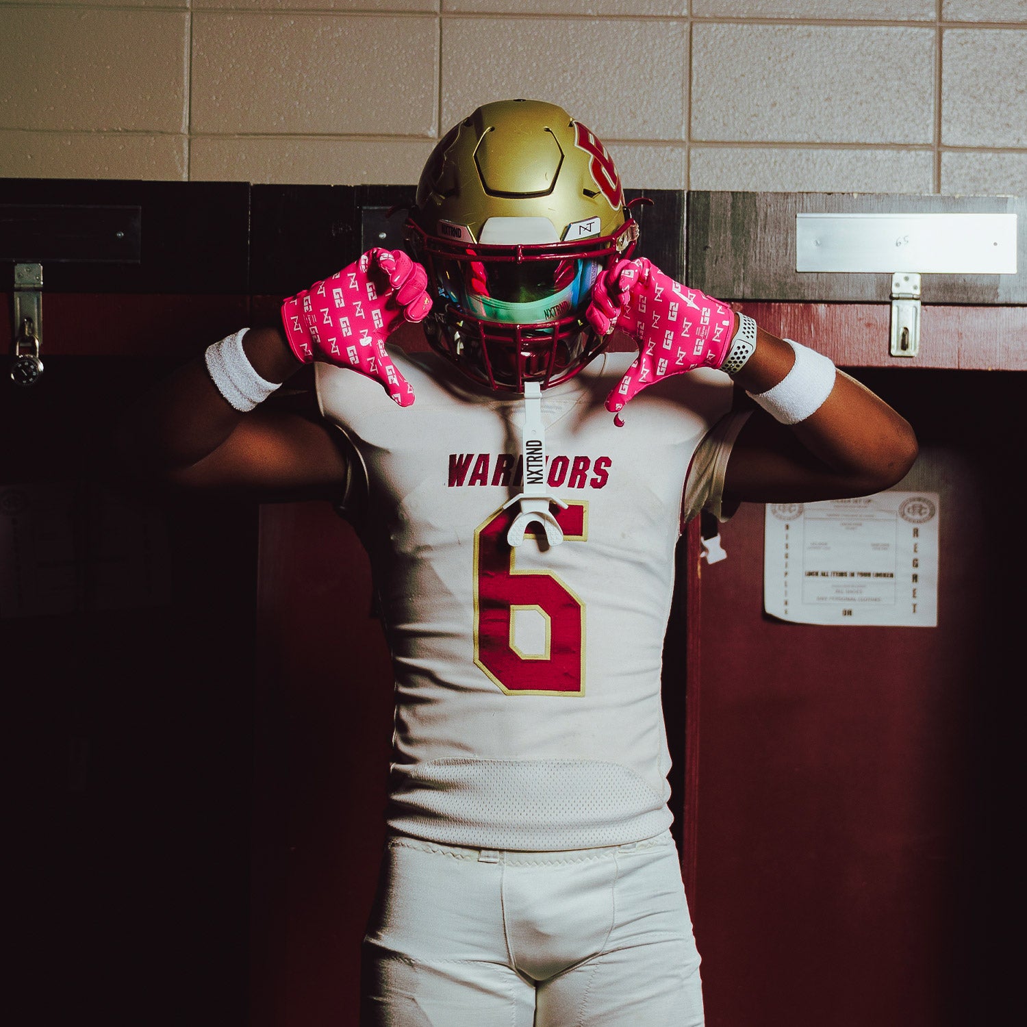 High School Football Player in Locker Room Wearing NXTRND G2 Pro Football Gloves Pink and VZR3 Football Visor Clear Black