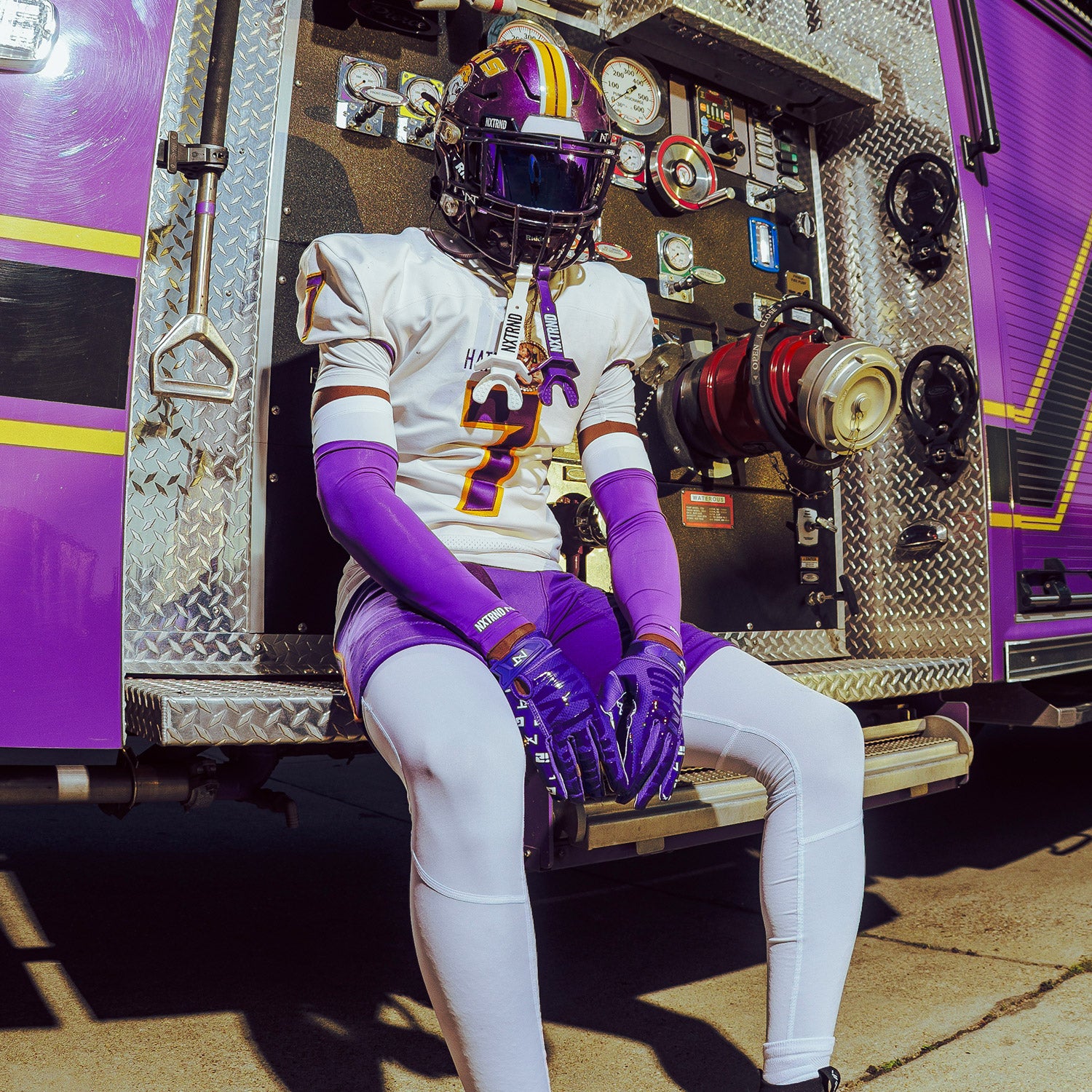 High School Football Player Wearing NXTRND Double Layer Compression Arm Sleeve Purple and TWO Football Mouthguard