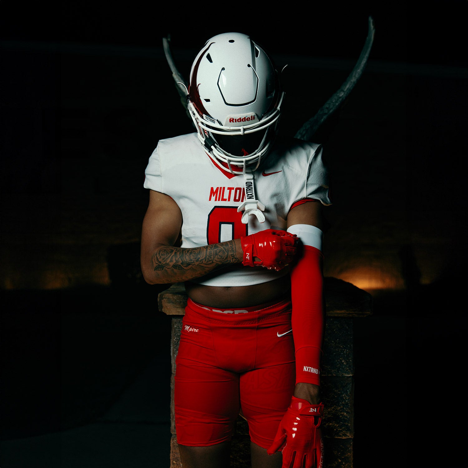 High School Football Player Wearing NXTRND Double Compression Arm Sleeves Red And G1 Pro Football Gloves Red