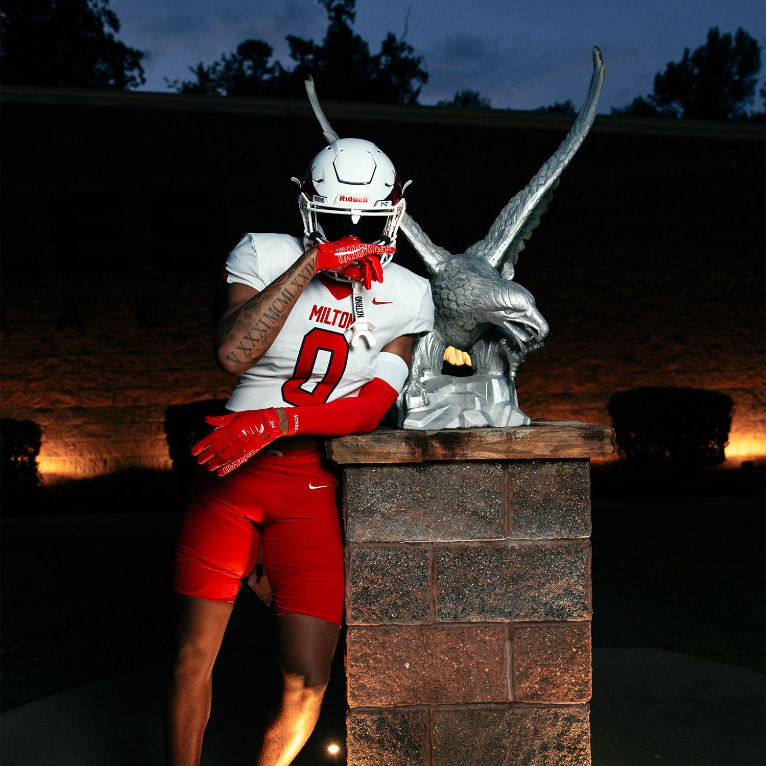 High School Football Player Wearing NXTRND Double Compression Arm Sleeves Red and G1 Pro Football Gloves