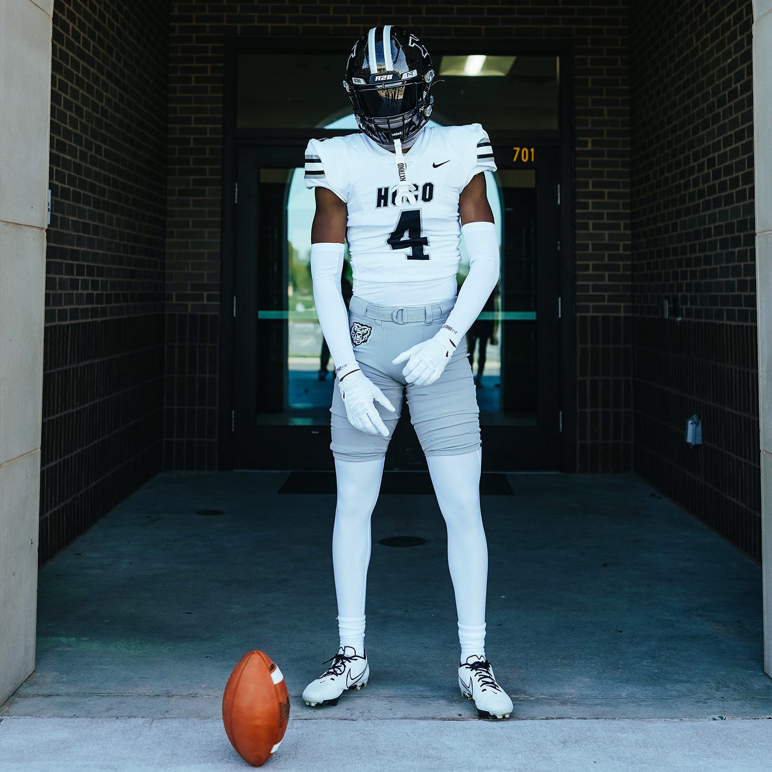 High School Football Player Wearing NXTRND Crew Mid Cut Padded Socks White and Compression Arm Sleeves White